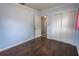 A bedroom features wood-look floors, a closet with sliding door, and open door to another room at 3300 Needles Dr, Orlando, FL 32810
