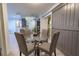 Stylish dining area with a glass table, four chairs, and a sliding barn door to the adjacent living area at 3300 Needles Dr, Orlando, FL 32810