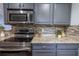Updated kitchen featuring stainless steel appliances, granite countertops, and a modern tile backsplash at 3300 Needles Dr, Orlando, FL 32810