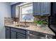 Well-lit kitchen featuring granite countertops, stainless steel sink, and ample cabinet space at 3300 Needles Dr, Orlando, FL 32810