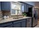 Bright kitchen with stainless steel appliances, granite countertops, and convenient access to the refrigerator at 3300 Needles Dr, Orlando, FL 32810
