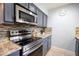 Well-equipped kitchen showcasing stainless steel appliances, granite counters, and stylish tile backsplash at 3300 Needles Dr, Orlando, FL 32810