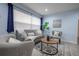 Bright living room featuring a gray couch, two chairs, a large front window, and neutral decor at 3300 Needles Dr, Orlando, FL 32810