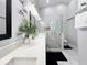 Elegant bathroom features a glass-enclosed shower, marble tiling, a plant accent and modern lighting at 3620 Benson Park Blvd, Orlando, FL 32829