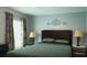 Cozy bedroom with soothing blue walls, lamps on either side of the bed and patterned curtains at 3620 Benson Park Blvd, Orlando, FL 32829