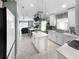 Bright, open kitchen boasts an island, stainless steel appliances and pot rack in this modern and clean design at 3620 Benson Park Blvd, Orlando, FL 32829