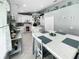 Eat-in kitchen featuring white cabinetry, a center island, and views of an adjacent room at 3620 Benson Park Blvd, Orlando, FL 32829