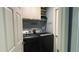 Well-organized laundry room with upper cabinets and modern black washer and dryer set at 3620 Benson Park Blvd, Orlando, FL 32829