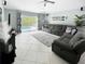 Bright living room with tile flooring, sliding glass doors to the pool, and comfortable gray sectional at 3620 Benson Park Blvd, Orlando, FL 32829