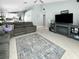 Open concept living room featuring an entertainment center and a large gray sofa at 3620 Benson Park Blvd, Orlando, FL 32829