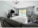 Living room showing tile floors, sliding glass doors to the pool, and comfortable gray sectional at 3620 Benson Park Blvd, Orlando, FL 32829