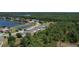 Aerial view showing a community with varied home styles, lush landscaping, and a tranquil pond at 3620 Benson Park Blvd, Orlando, FL 32829