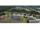 Aerial view of a residential neighborhood featuring well-maintained homes, mature trees, and a scenic pond at 3620 Benson Park Blvd, Orlando, FL 32829