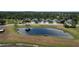 Aerial view of a peaceful residential area featuring tidy homes, green spaces, and a pond at 3620 Benson Park Blvd, Orlando, FL 32829