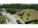 Aerial view of a community park with a playground and a grassy field, surrounded by mature trees and green lawns at 3620 Benson Park Blvd, Orlando, FL 32829
