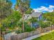 Backyard view of the blue home, bordered by a wooden fence and mature palm trees at 420 S Oak Ave, Sanford, FL 32771