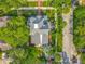 Aerial view of the blue home showcasing its manicured yard, landscaping, and mature trees surrounding the property at 420 S Oak Ave, Sanford, FL 32771