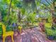 Beautiful garden backyard showcasing patio with yellow chairs and a brick-paved pathway at 420 S Oak Ave, Sanford, FL 32771