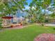 Expansive backyard featuring lush landscaping, brick pathways, patio, and charming blue exterior at 420 S Oak Ave, Sanford, FL 32771