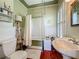 Cozy bathroom with a claw foot tub, pedestal sink, and wainscoting at 420 S Oak Ave, Sanford, FL 32771