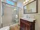 Bathroom with a large glass shower and a beautifully detailed vintage vanity with a marble countertop and vintage mirror at 420 S Oak Ave, Sanford, FL 32771