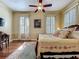Spacious main bedroom with wood floors, ceiling fan and two windows providing natural light and a floral patterned rug at 420 S Oak Ave, Sanford, FL 32771