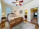 Light and bright main bedroom with wood floors, a ceiling fan, and an ornate wood bed frame with access to ensuite bathroom at 420 S Oak Ave, Sanford, FL 32771