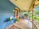 Wrap-around porch with blue siding, red door, and cozy seating area with rug at 420 S Oak Ave, Sanford, FL 32771