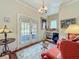 Cozy sitting room with chandelier, double french doors to balcony, and charming decor for relaxing or entertaining at 420 S Oak Ave, Sanford, FL 32771