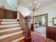 Elegant staircase with wood railing leading to the upper level, enhanced by wainscoting and chandelier at 420 S Oak Ave, Sanford, FL 32771