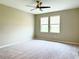 Spacious bedroom with carpet flooring, ceiling fan, and natural light from two windows at 6268 Great Bear Dr, Lakeland, FL 33805
