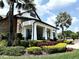 Clubhouse exterior with large white columns, stone accents, palm trees, and decorative landscaping at 6268 Great Bear Dr, Lakeland, FL 33805