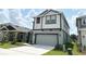 Gray two-story home featuring a two-car garage, a long driveway, and nicely kept landscaping at 6268 Great Bear Dr, Lakeland, FL 33805