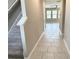 Inviting hallway with tile flooring leading to a bright living area and carpeted stairs at 6268 Great Bear Dr, Lakeland, FL 33805
