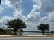 Scenic lake view with mature trees on a sunny day showcasing the tranquil community setting at 6268 Great Bear Dr, Lakeland, FL 33805