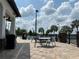 Pool patio featuring tables, lounge chairs, manicured shrubs, and clear skies on a beautiful day at 6268 Great Bear Dr, Lakeland, FL 33805