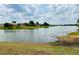 Beautiful water view with houses across the lake and a sunny, cloudy blue sky at 6268 Great Bear Dr, Lakeland, FL 33805