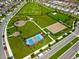 Aerial view of community park including playground, basketball court, pickleball court, and walking paths at 6328 Whip O Will Ln, St Cloud, FL 34771