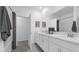 Bright bathroom with double sink vanity, large mirror, and shower/tub combo with modern fixtures at 6328 Whip O Will Ln, St Cloud, FL 34771