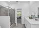 Bright bathroom featuring a glass enclosed shower, dual sink vanity with modern faucets and a neutral color palette at 6328 Whip O Will Ln, St Cloud, FL 34771