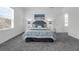 Bright bedroom with a queen bed, gray carpet, white walls, and natural light streaming through the window at 6328 Whip O Will Ln, St Cloud, FL 34771