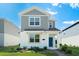 Charming two-story home with gray siding, white accents, a blue front door, and a well-manicured lawn at 6328 Whip O Will Ln, St Cloud, FL 34771