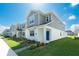 Charming two-story home with gray siding, white accents, a blue front door, and a well-manicured lawn at 6328 Whip O Will Ln, St Cloud, FL 34771