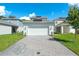 Two car garage with paved driveway in front of a modern home with well-manicured lawn at 6328 Whip O Will Ln, St Cloud, FL 34771