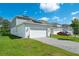 Two car garage with paved driveway in front of a modern home with solar panels at 6328 Whip O Will Ln, St Cloud, FL 34771