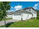 Two car garage with paved driveway in front of a modern home with solar panels and small garden at 6328 Whip O Will Ln, St Cloud, FL 34771