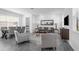 Modern living room with gray sofa, accent chairs, a large mirror, and views of the kitchen and dining area at 6328 Whip O Will Ln, St Cloud, FL 34771