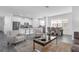 Bright, open-concept living room with modern furnishings, adjacent to a kitchen with stainless steel appliances at 6328 Whip O Will Ln, St Cloud, FL 34771