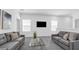 Comfortable living room with modern sofas, sleek glass table, and a wall-mounted TV for entertainment at 6328 Whip O Will Ln, St Cloud, FL 34771