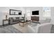 Bright living room featuring a gray sofa, two chairs, a wooden cabinet and a modern coffee table at 6328 Whip O Will Ln, St Cloud, FL 34771